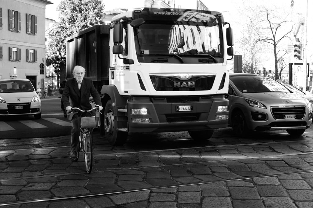 man on bike cycles in streets of milan black and white tell a story 32